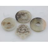 Four Chinese green hardstone circular pendants