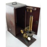 A late 19th century monocular microscope, with a lacquer brass body,