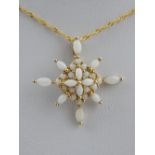 A 9 carat yellow gold and opal starburst cluster pendant, suspended on a 9 carat yellow gold chain.