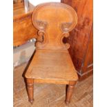 A late Victorian oak hall chair on turned tapered legs.