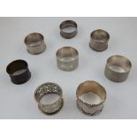 Six late Victorian/ Edwardian silver serviette rings with cast and engine tuned decoration together