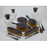 A tortoiseshell and silver mounted dressing table set, including four various brushes, hand mirror,