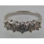 A white metal and five stone diamond ring, set round cut stones of approx. 1.40 carats combined.