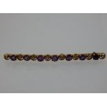 A 15 carat yellow gold, amethyst,and split seed pearl bar brooch.