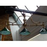 A ceiling mounted brass billiard table lamp, having three green glass shades. L: 110cm H: 55cm W: