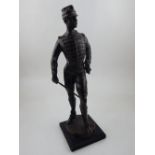 A 20th century dark patinated bronze of a standing Belgian cavalry officer on square ebonised wood
