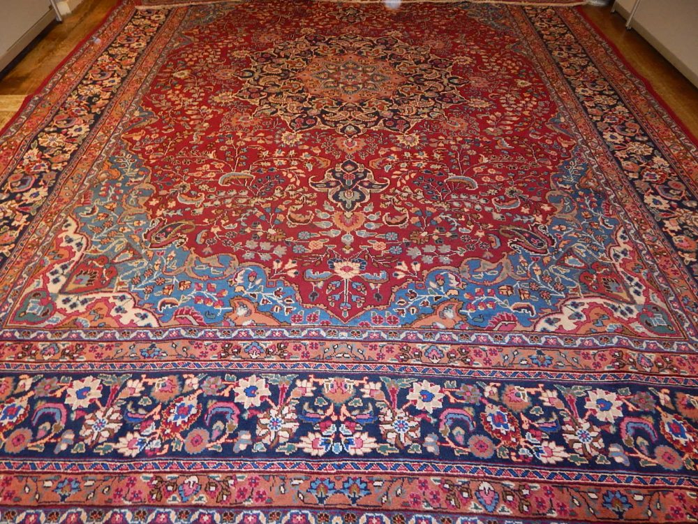 A red ground Tabriz carpet, decorated with tear drop medallion to centre, on a foliate ground,