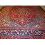 A red ground Tabriz carpet, decorated with tear drop medallion to centre, on a foliate ground,