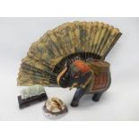 A fan with pierced guards, a painted wooden model of an elephant, green hardstone fish and a