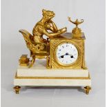 A 19th Century mantel clock with white enamel dial, in a gilded ormolu case with reclining child