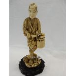 An early 20th Century Japanese sectional ivory depicting a fruit salesman carrying a basket of