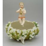 A German model of a boy playing a pipe, the base encrusted with flowers,