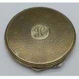 A silver compact with initials