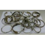 Twenty-five silver and white metal bangles,