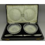 A pair of glass butter dishes with silver knives, cased, W.H.