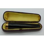 A cased cheroot holder with a hallmarked 9ct gold rim,