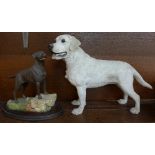 A large model of a Labrador and a Naturecraft figure of a chocolate Labrador on a wooden plinth