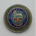 A brooch set with an enamelled George IV shilling,