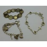 A silver lucky charm bracelet, a silver coin bracelet and another silver bracelet,