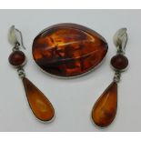 An amber and white metal brooch and a pair of earrings, earrings marked .