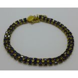 A 14ct gold overlay on sterling silver tennis bracelet with eighty blue sapphires