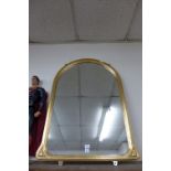 A gilt arched framed mirror