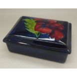 A Moorcroft hibiscus trinket box with worn paper label,