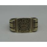 A white metal ring with crest,