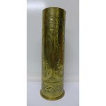 A brass trench art shell case vase decorated with Egyptian figures, the base marked Karlsruhe, 1912,