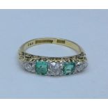 An 18ct gold, emerald and old cut diamond five stone ring, 0.5ct diamond weight, 3.