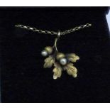 A 15ct gold acorn pendant set with two pearls on a 9ct gold chain, (1.