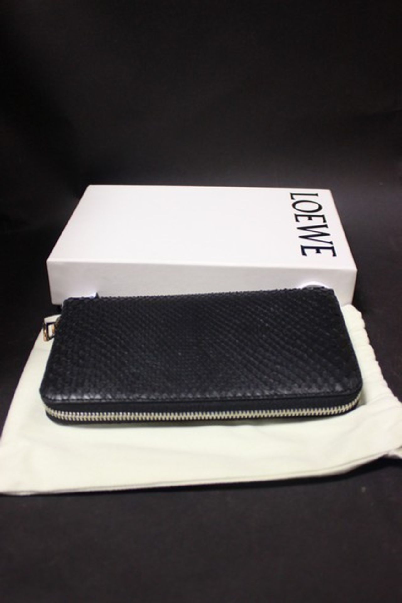 A Loewe black python zip around long wallet, with smooth black leather lining, sixteen credit card