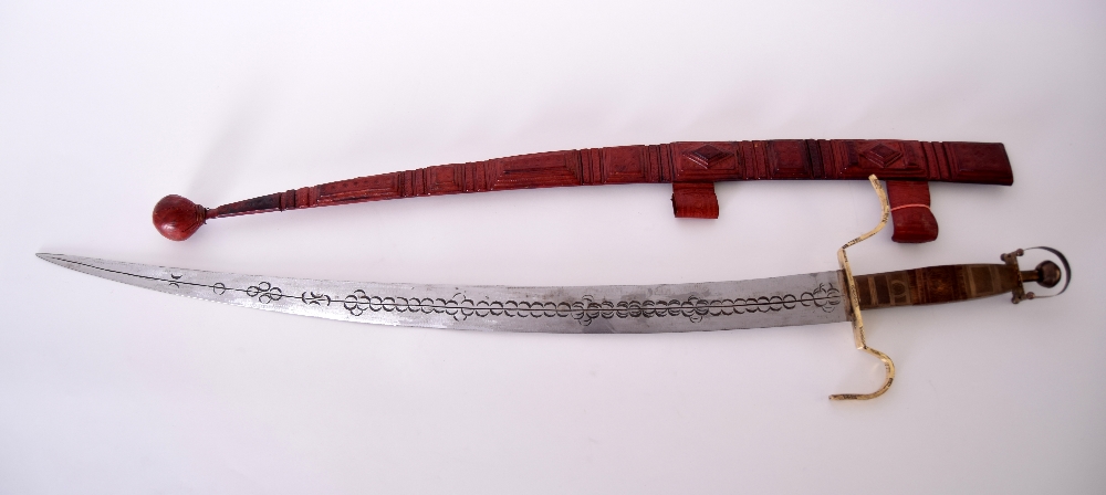 An early 20th century Tuareg/Berber curved sword and thick leather scabbard with traditional