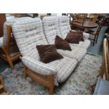 An Ercol light elm three seater sofa with checkered oatmeal fabric