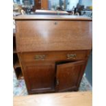 A 20th century oak bookshelf with bureau of small proportions 75cmW