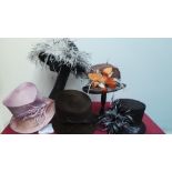 Mixed box of five hats mostly decorated with feathers, all new and with tags.