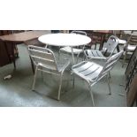 A white painted 20th century design dining table with metal legs with four metal dining chairs