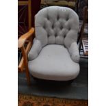 A Victorian button back nursing chair with turned legs and castors,