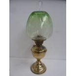 A Victorian brass oil lamp with acid etched green glass shade, and glass chimney,