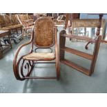 An early 20th century bent wood Thonet type rocking chair with a hanging shelf