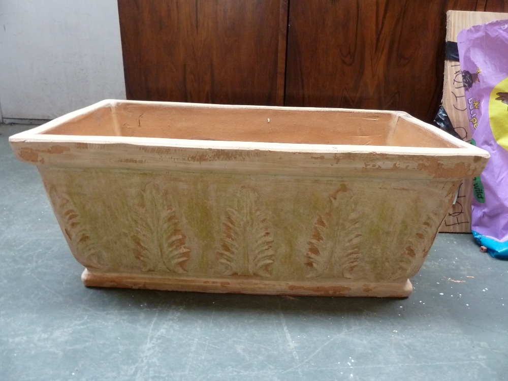 A rectangular terracotta planter decorated with ferns,