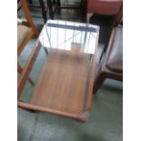 A modern teak coffee table with glass rectangular top