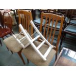 A pair of cream cushioned dining chairs with slat backs,