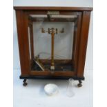 A set of laboratory scales in a glazed wooden case with various makers and repairers labels