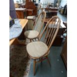 A set of four light elm Ercol spindle back dining chairs