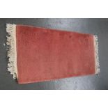 A pink runner rug with cream fringing 130cmL