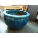 A large round stoneware planter, turquoise and blue glazed,