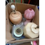 An oil lamp, a pink side lamp with pink shade, an octagonal beige lamp base,