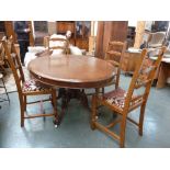 A Victorian oval oak pedestal table on turned supports and scrolling legs on castors with a set of