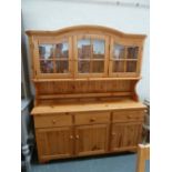 A modern pine dresser, arched top over three glazed doors,